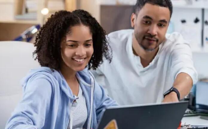 Father and her daughter working together with their laptop